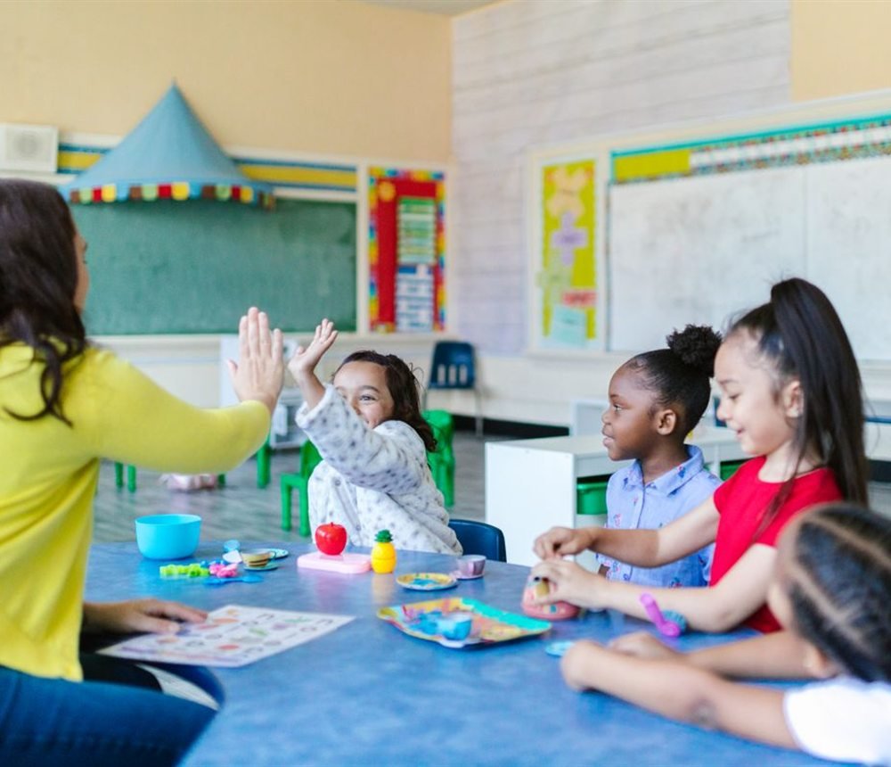 An educator working with children at the table