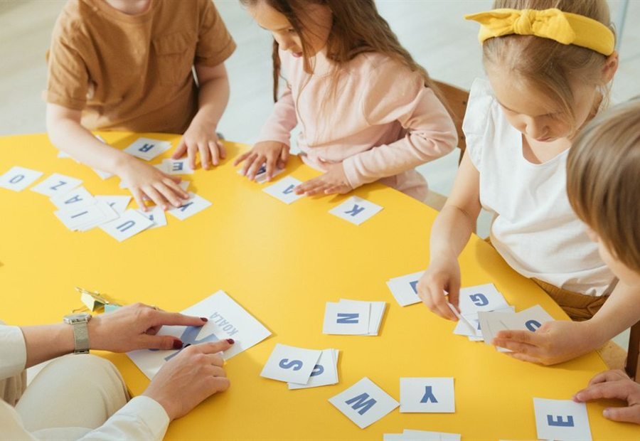 Children matching letter cards at the table